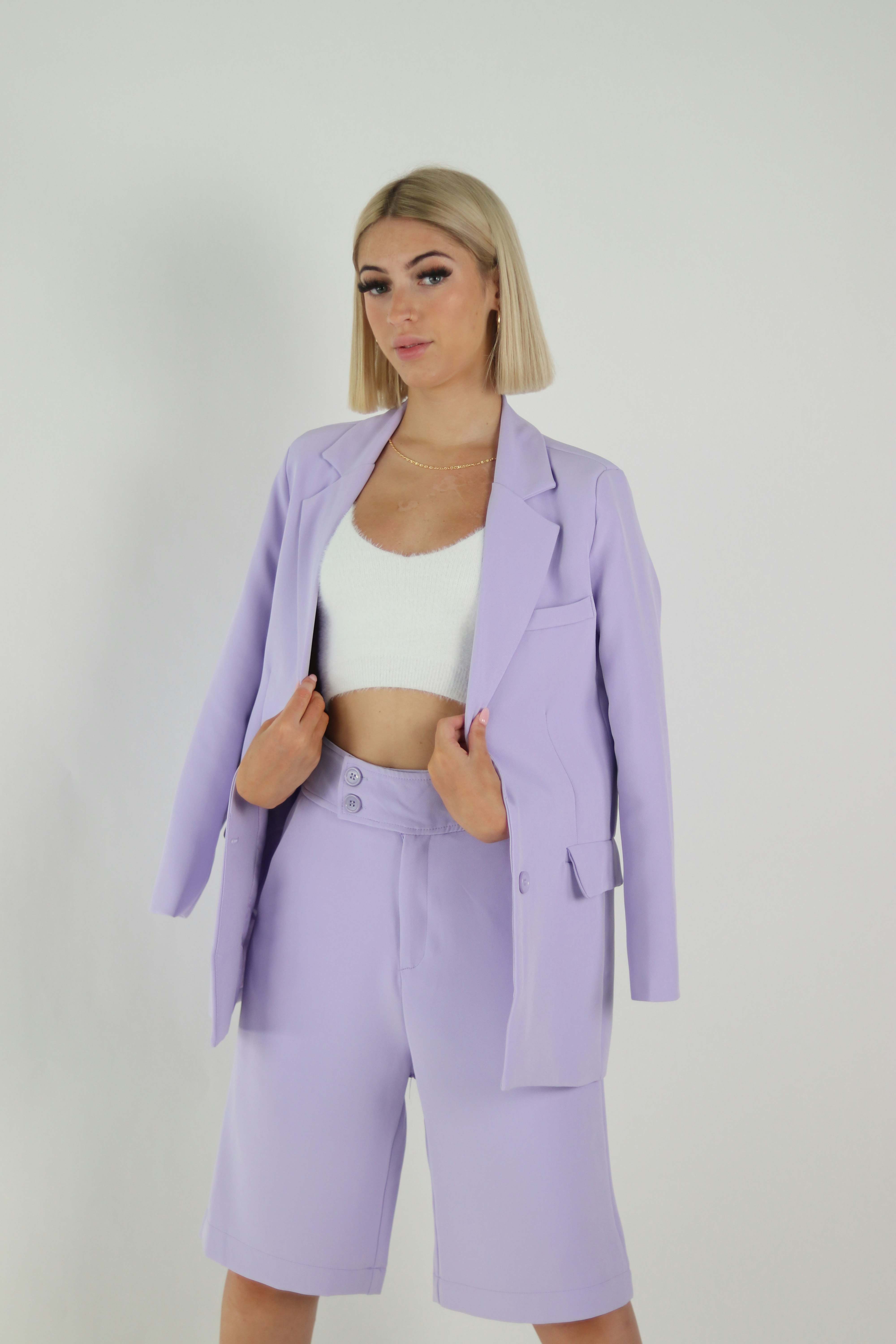 woman in white crop top and pink blazer